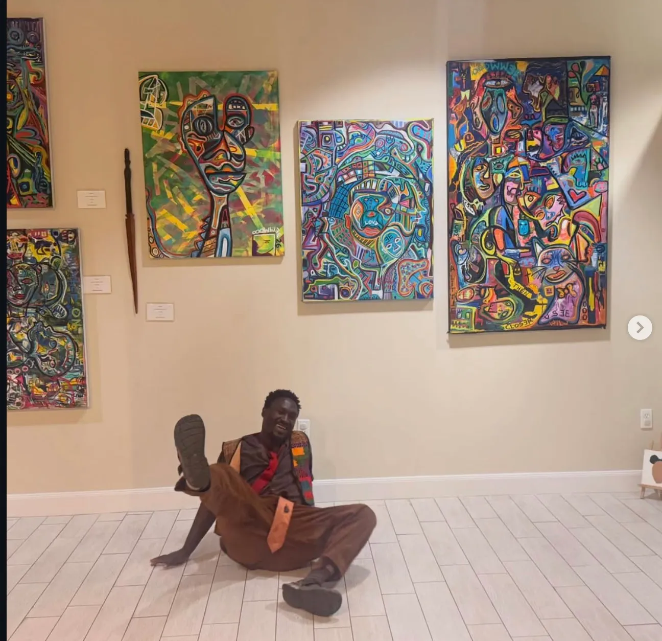 Ooowwee cracking up on a gallery floor beneath a wall of his paintings