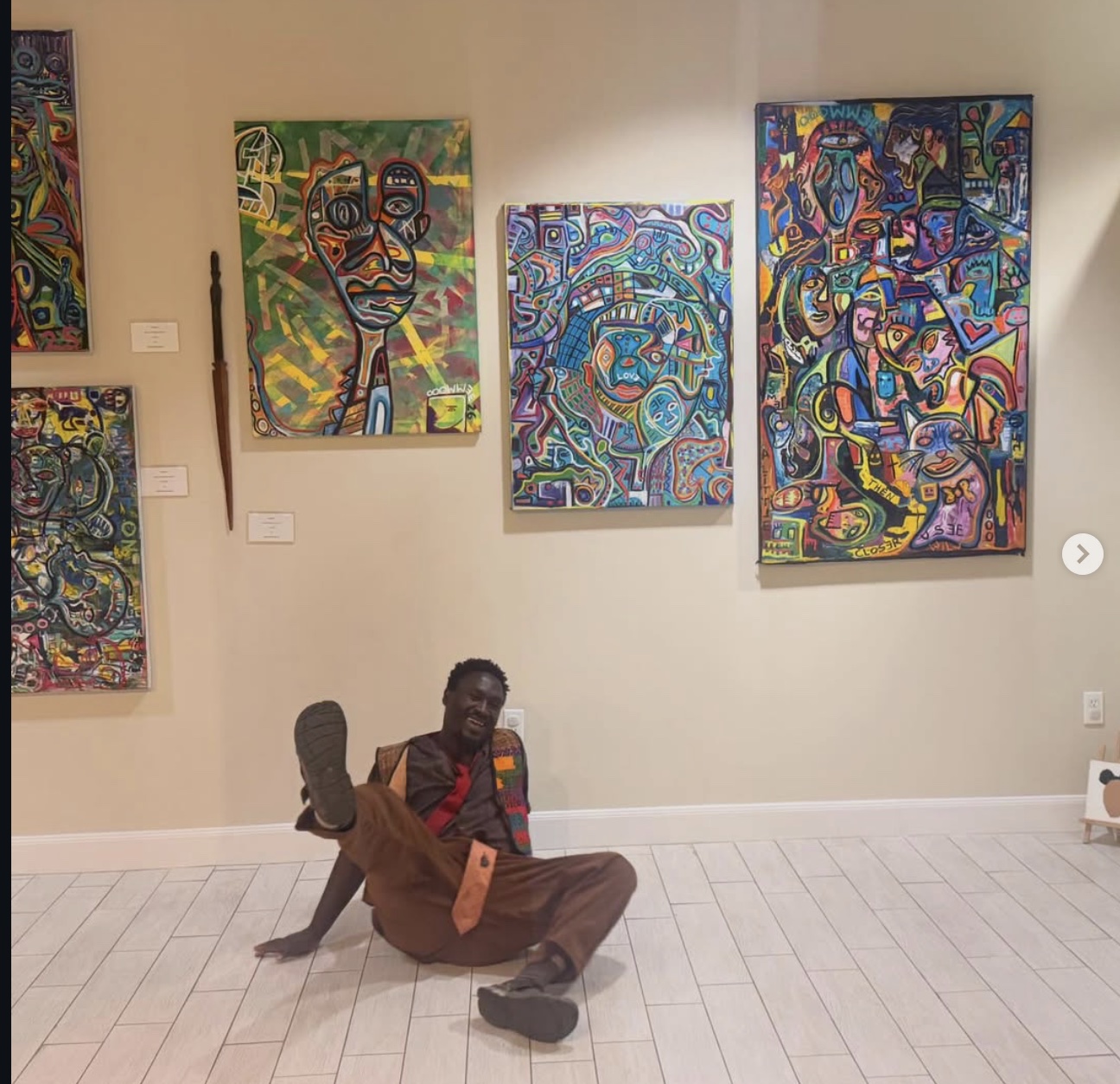 Ooowwee cracking up on a gallery floor beneath a wall of his paintings
